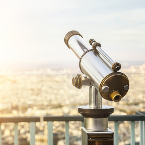 Telescope on a balcony with view over city