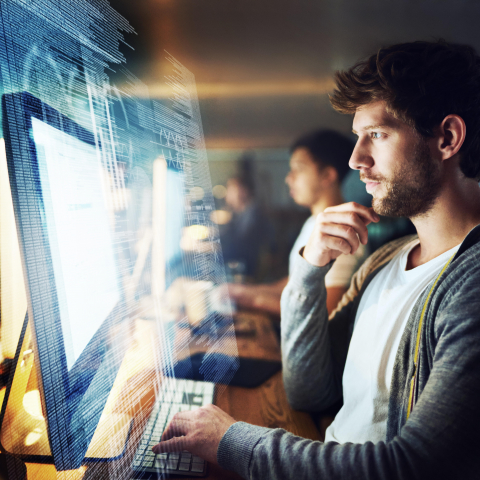 Man working in an office in front of a screen